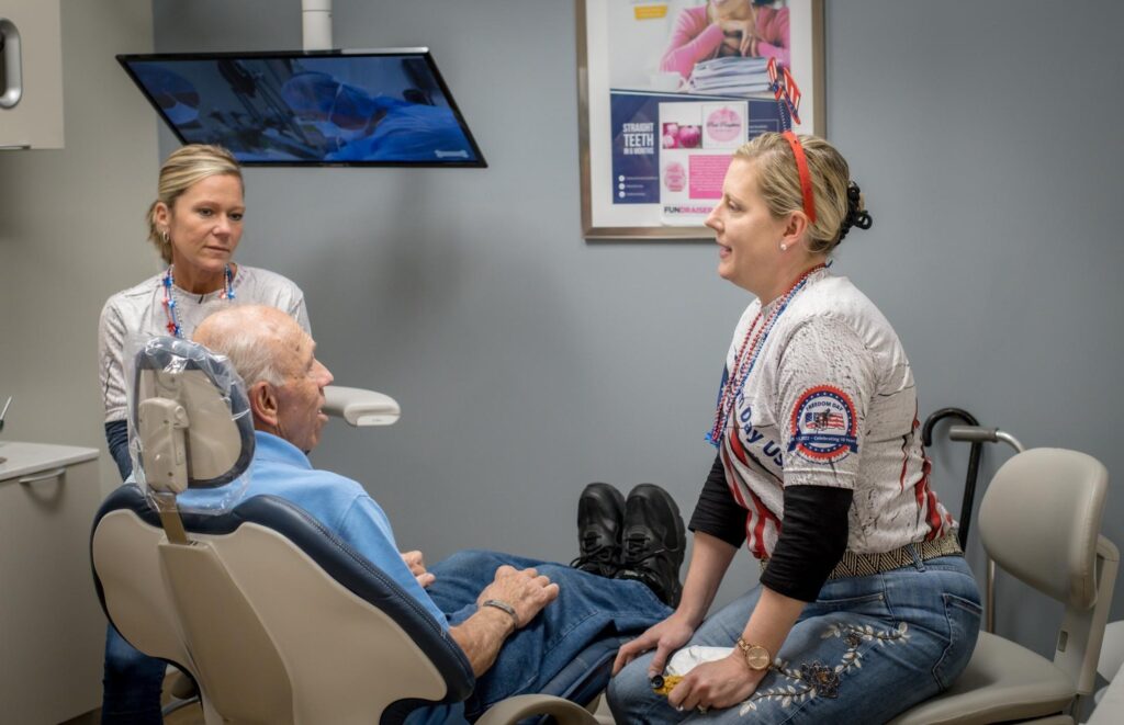 Patient in a dental chair talking to dentists